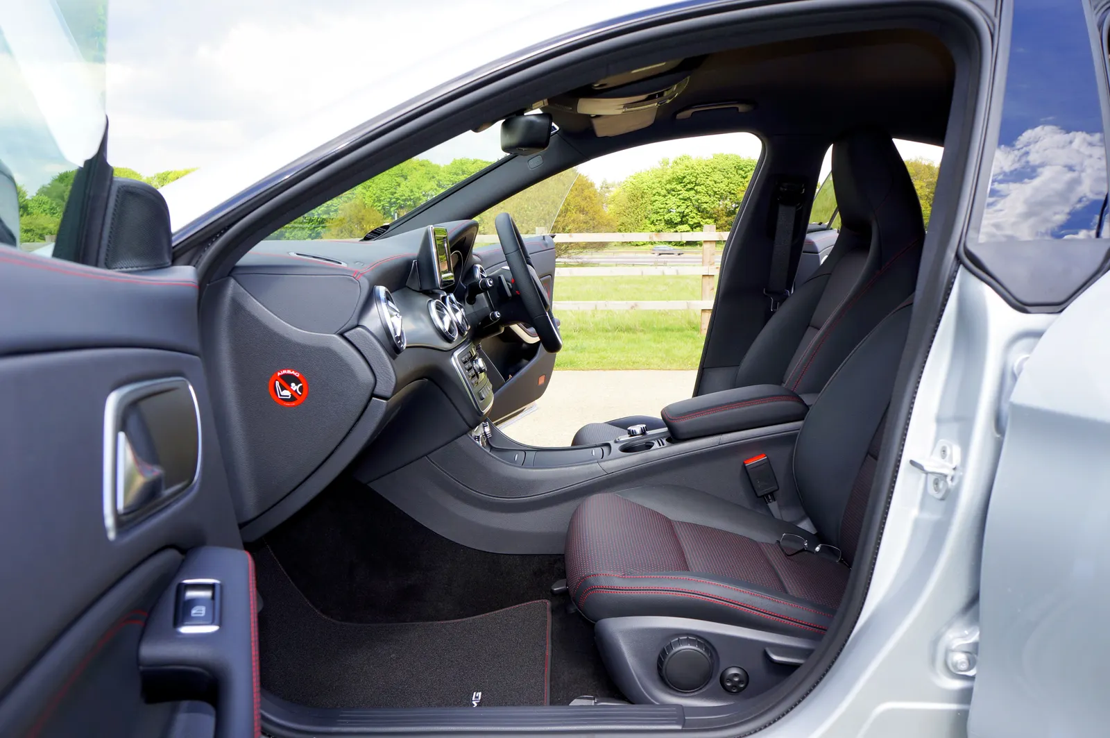 A clean vehicle cabin with sculpted seats and a center console