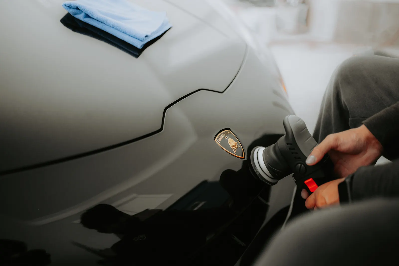 Close-up of paint care on a dark sports car hood