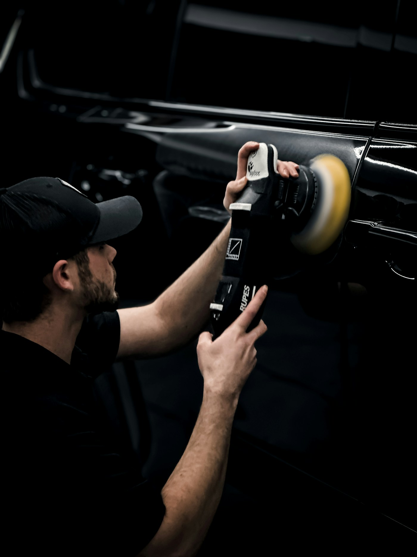 Machine polishing a black vehicle panel