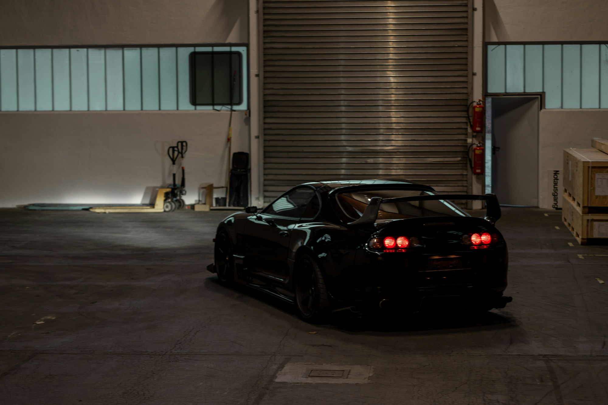 Black sports car under the lights of an industrial garage